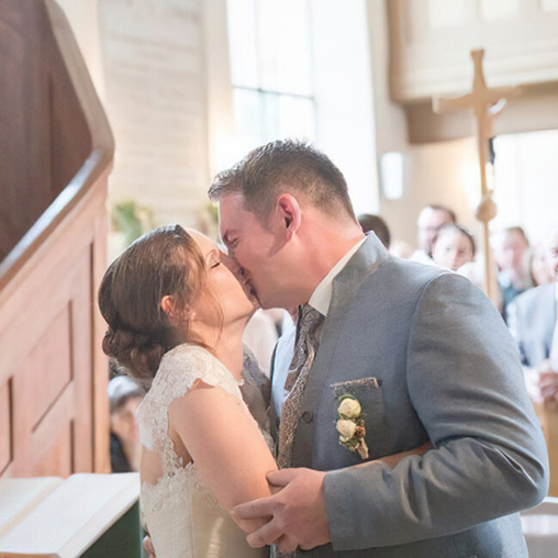 Hochzeitsfoto vom Hochzeitskuss in der Kirche bei der Trauung