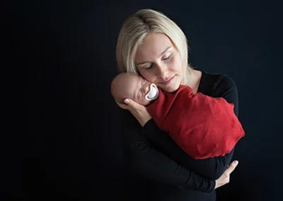 Mama und Baby in einem zauberhaften Fotoshooting vor schwarzem Hintergrund